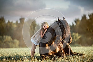 Little girl with black friesian stallion