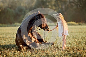 Little girl with black friesian stallion