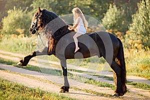 Little girl with black friesian stallion