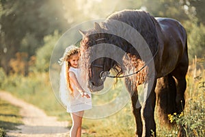 Little girl with black friesian stallion