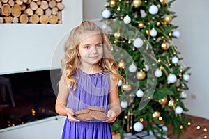 A little girl with blond hair prepared treats for Sanda. Christmas background, new year concept