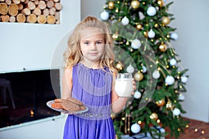 A little girl with blond hair prepared treats for Sanda. Christmas background, new year concept