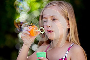 Little girl blowing bubbles