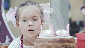 Little girl blowing candles on birthday cake
