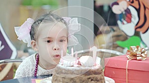 Little girl blowing candles on birthday cake