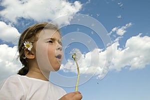 Little girl blowing dandelion