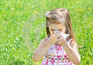 Little girl is blowing her nose