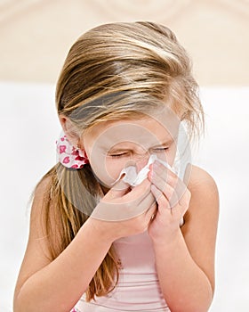 Little girl blowing her nose in a great effort