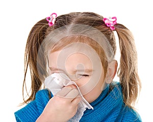 Little girl blowing her nose in a great effort closeup isolated