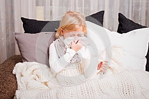 Little girl blowing her nose in napkin