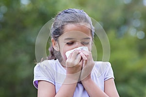 Little girl blowing his nose