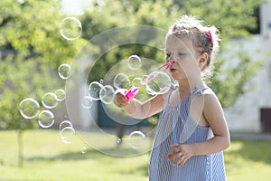 Little girl blowing soap bubbles