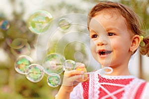 Little girl blowing soap bubbles