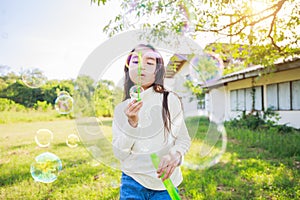 A little girl blowing soap bubbles with have fun and enjoyed on sunny days