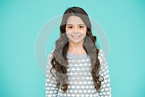 Little girl blue background. Smiling small girl with long hair. Beauty and health. Childhood and girlhood. International photo