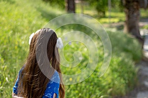 Little Girl in Blue Dress looking at golden field at park