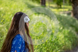 Little Girl in Blue Dress Smiling in Front of Field with Flowers