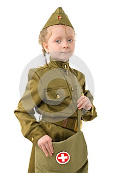 A little girl with blue eyes in a Soviet military nurse`s uniform. Concept for the Victory Day in World War II on May 9