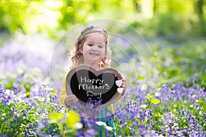 Little girl in bluebelss flowers