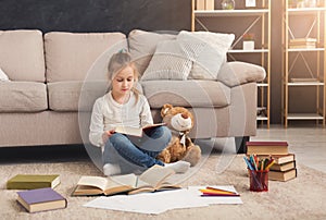 Little girl with book and her favorite toy at home