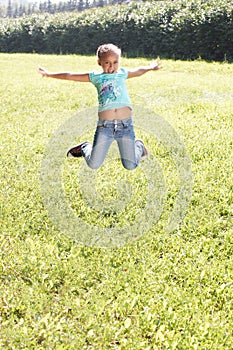 Little girl. Bounce. Juicy green grass