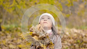 Little girl with a bouquet of autumn leaves