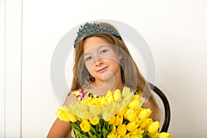 Little girl with a bouquet of tulips.The concept of the awakening of nature after winter