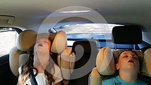 Little girl and boy asleep in the car.