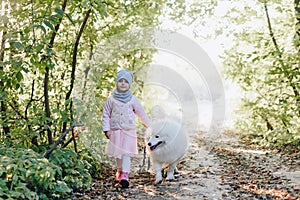 Little girl and boy in autumn on nature with a dog