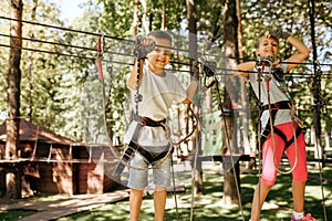 Little girl and boy climbs in rope park