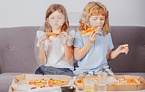 Little girl and boy eat pizza. Hungry children eating pizza. Unhealthy fast food.