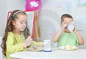 Little girl and boy eating