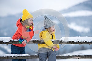 Little girl and boy enjoying a day out playing in the winter forest. Children siblings having fun in beautiful winter