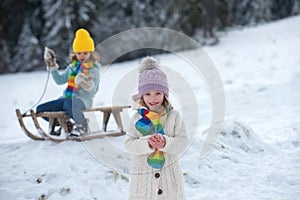 Little girl and boy enjoying a day out playing in the winter forest. Children siblings having fun in beautiful winter