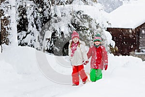 Little girl and boy enjoying sleigh ride. Child sledding. Toddler kid riding a sledge. Children play outdoors in snow. Kids sled