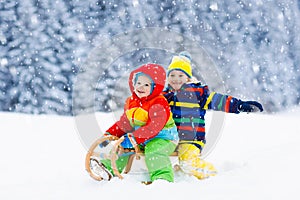 Kids play in snow. Winter sleigh ride for children