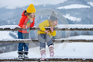 Little girl and boy enjoying winter. Children play outdoors in snow. Outdoor fun for family Christmas vacation.