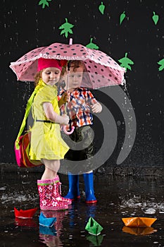 Little girl and boy hiding from the water under