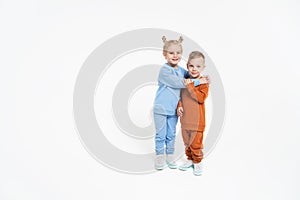 A little girl and a boy hug. Children& x27;s love. On a monochromatic background, children in sportswear. Blue tracksuit