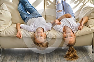 Little girl and boy are lying on their backs on sofa
