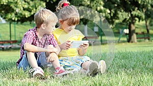 Little girl and boy play with tablet