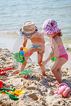 Little girl and boy playing on the beach