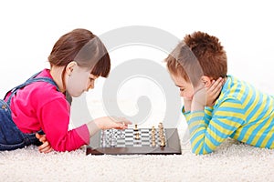 Little girl and boy playing chess