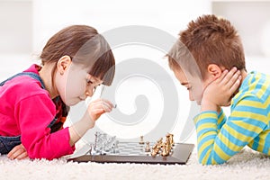 Little girl and boy playing chess