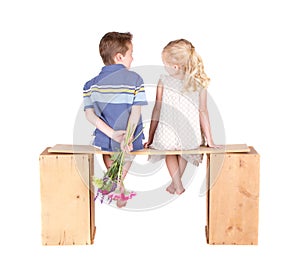 Little girl and boy sitting on a wooden bench