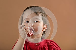 Little girl breathing asthmatic medicine inhaler photo