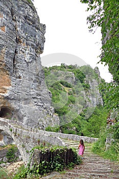 A little girl on a bridge in the national park of Vikos-Aoos in Greece