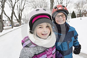 Little girl and brother enjoying ice skating in winter season