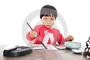 A little girl with a brush in her right hand and a seal in her left hand on a white background