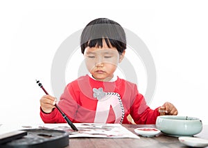 A little girl with a brush in her right hand and a seal in her left hand on a white background